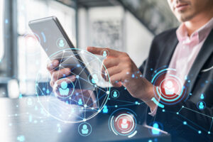 Mann im Anzug bedient ein Tablet, umgeben von digitalen Netzwerk-Symbolen mit vernetzten Personenicons